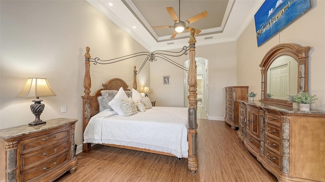 6919 Dominion Ln, Lakewood Ranch, FL 34202 - bedroom with light wood-type flooring, a tray ceiling, ornamental molding, and a ceiling fan