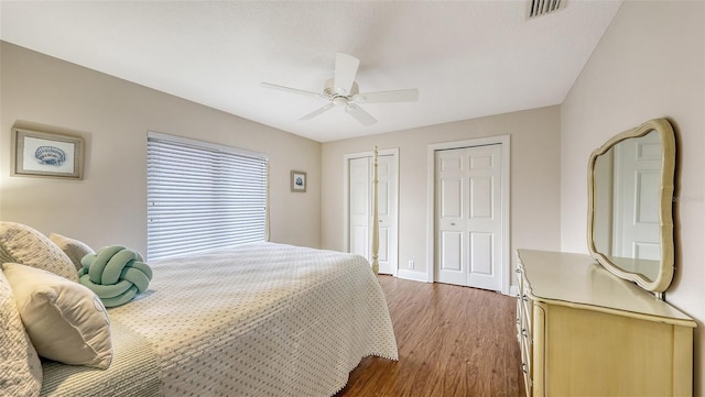 6919 Dominion Ln, Lakewood Ranch, FL 34202 - bedroom featuring two closets, wood finished floors, and ceiling fan