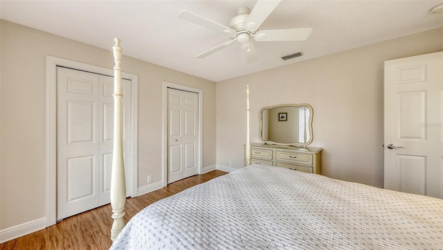 6919 Dominion Ln, Lakewood Ranch, FL 34202 - bedroom with wood finished floors, multiple closets, and a ceiling fan