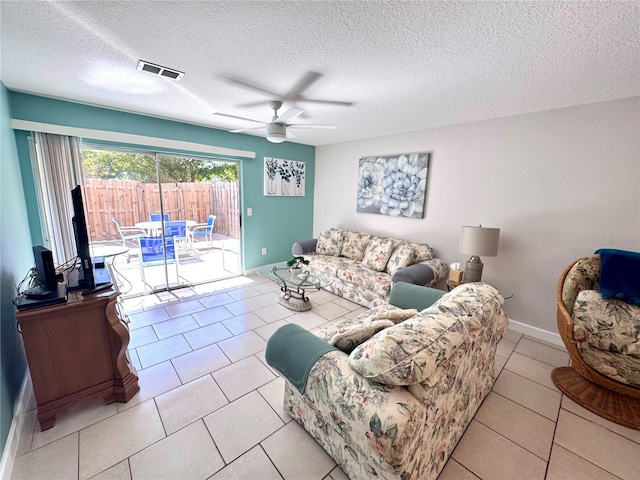 living area featuring a textured ceiling, ceiling fan, visible vents, and light tile patterned floors