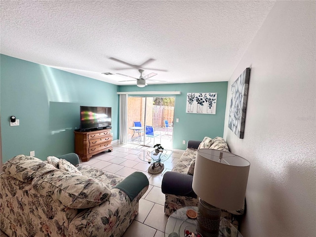 living room featuring light tile patterned floors, ceiling fan, and a textured ceiling