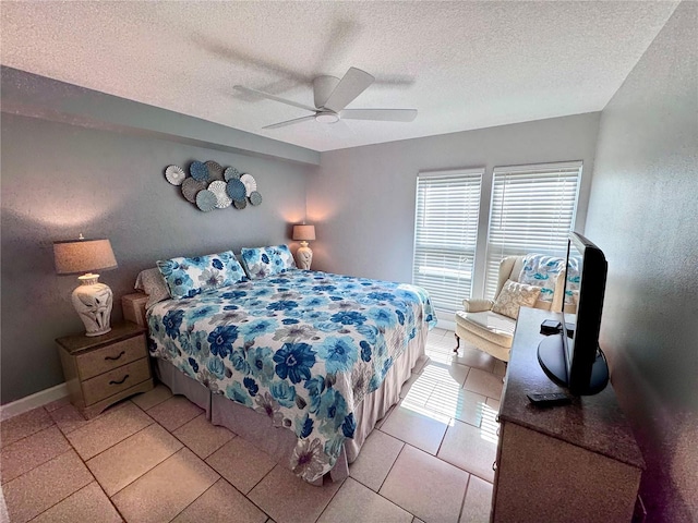 bedroom featuring light tile patterned floors, baseboards, ceiling fan, and a textured ceiling