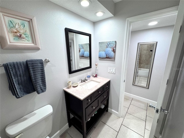 bathroom with tile patterned floors, baseboards, vanity, and toilet