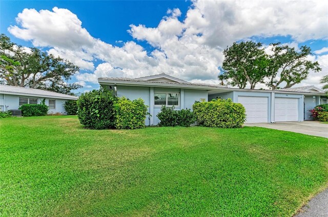 single story home featuring a front yard, stucco siding, concrete driveway, an attached garage, and central air condition unit