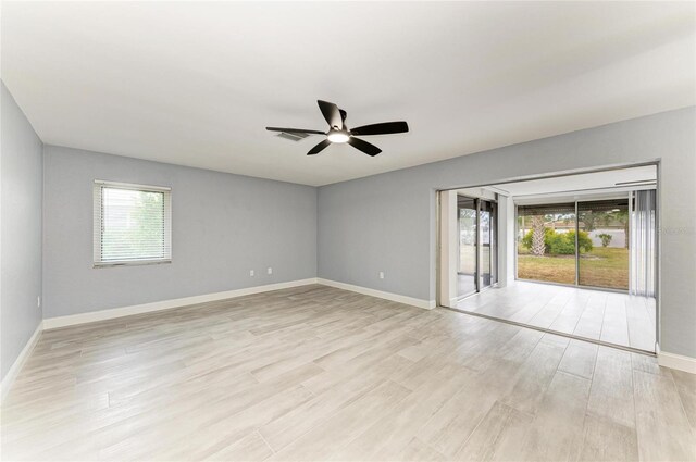 empty room featuring light wood-style floors, baseboards, and a ceiling fan