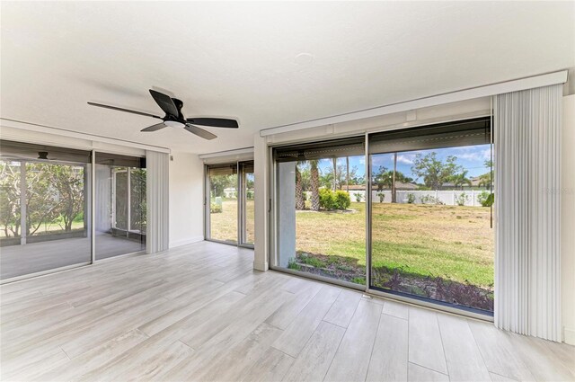 unfurnished room with baseboards, a ceiling fan, and wood finished floors