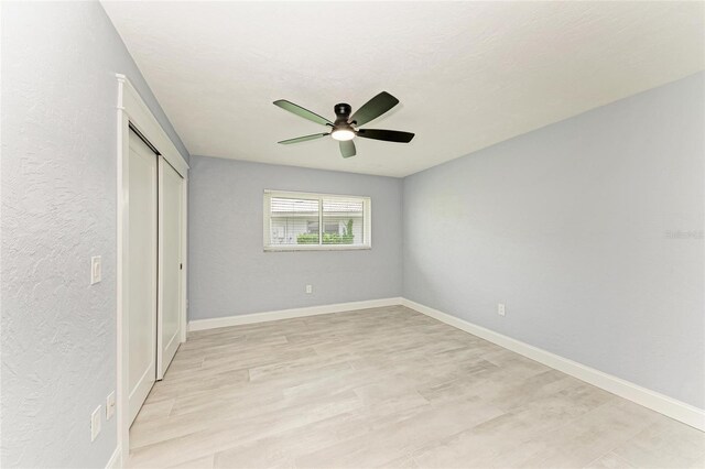 unfurnished bedroom featuring a ceiling fan, baseboards, a textured wall, and a closet