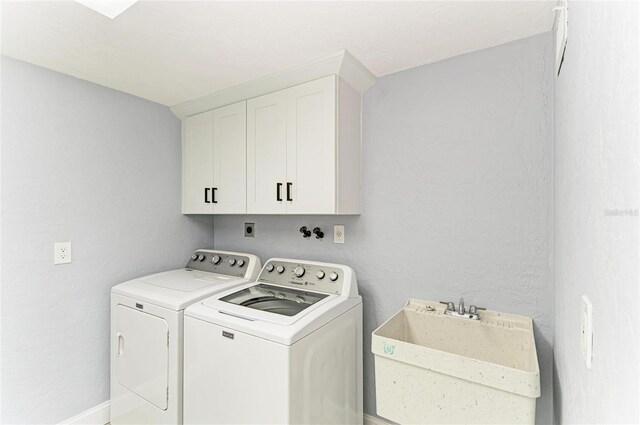 laundry room with a sink, cabinet space, and washer and dryer
