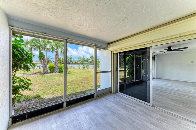 unfurnished sunroom with a water view and a ceiling fan