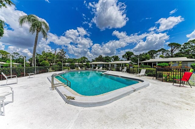 pool with fence and a patio