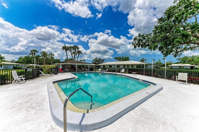 pool featuring fence and a patio area