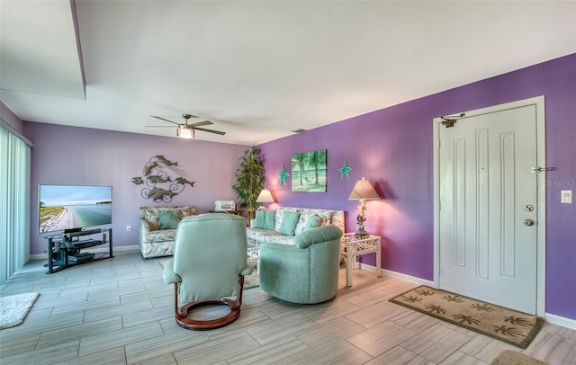 living room with wood tiled floor, baseboards, and a ceiling fan
