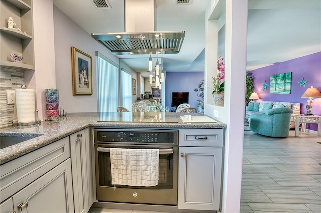 kitchen featuring visible vents, stainless steel oven, extractor fan, and open floor plan