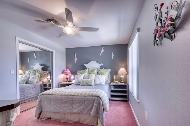 carpeted bedroom featuring a closet, ceiling fan, visible vents, and multiple windows