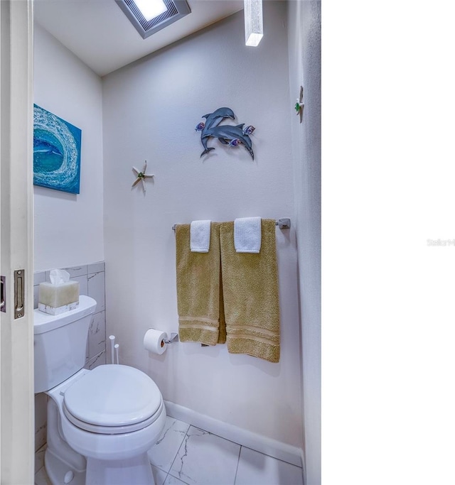 bathroom with baseboards, marble finish floor, toilet, and visible vents