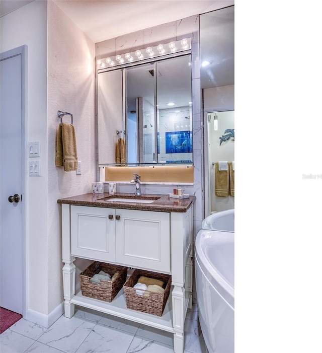 bathroom featuring vanity, baseboards, a bathtub, and marble finish floor
