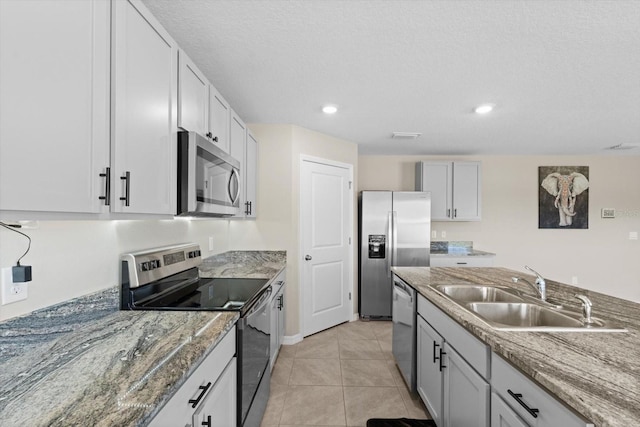 6314 Distant Haze Pl, Palmetto, FL 34221 - kitchen with stainless steel appliances, a sink, stone counters, light tile patterned flooring, and recessed lighting