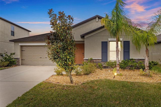 ranch-style home with an attached garage, stucco siding, stone siding, and concrete driveway