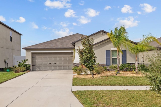 ranch-style home featuring an attached garage, a front lawn, driveway, and stucco siding