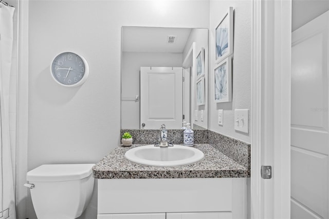 full bathroom with vanity, visible vents, and toilet