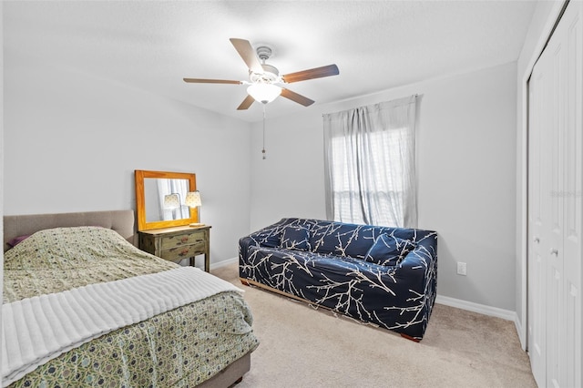 bedroom with a ceiling fan, baseboards, carpet, and a closet