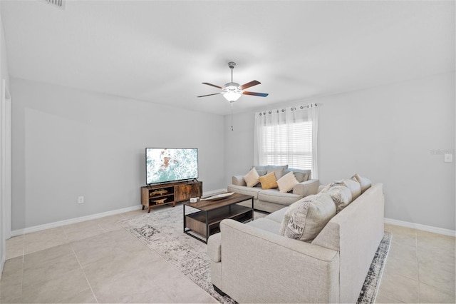 living room with baseboards, ceiling fan, and light tile patterned flooring