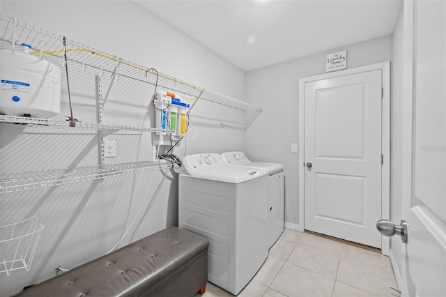 laundry room with baseboards, light tile patterned floors, laundry area, and washer and clothes dryer