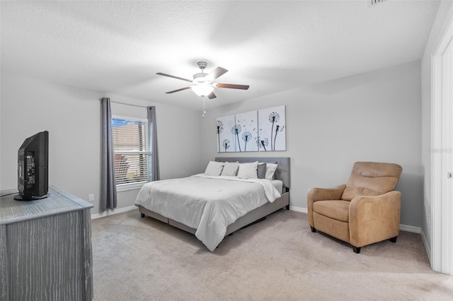 bedroom featuring light colored carpet, a ceiling fan, and baseboards