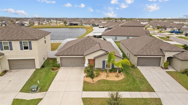 view of front of house featuring a water view, stucco siding, driveway, and a residential view