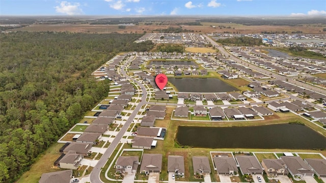 bird's eye view featuring a water view, a residential view, and a wooded view