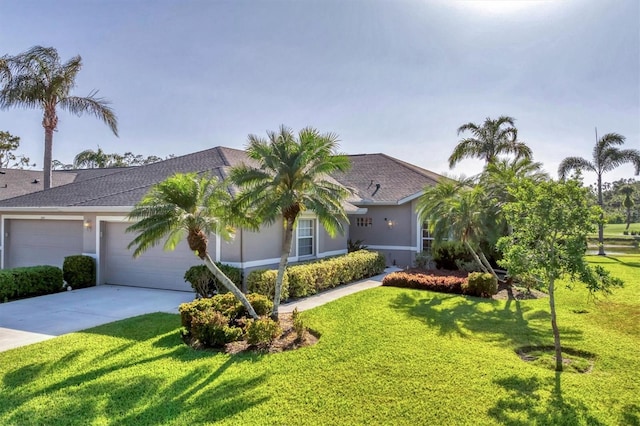single story home with a garage, a front yard, stucco siding, a shingled roof, and driveway