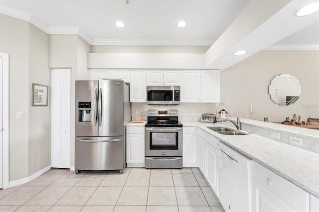 kitchen featuring appliances with stainless steel finishes, a sink, light tile patterned floors, light stone counters, and white cabinets