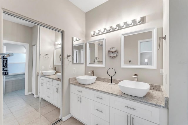 full bathroom featuring double vanity, tile patterned floors, and a sink