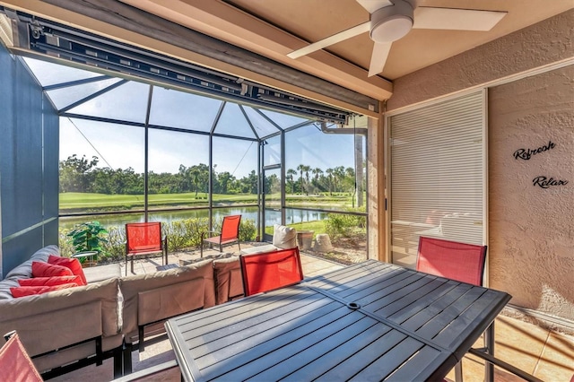 view of patio featuring ceiling fan, outdoor dining area, a water view, an outdoor living space, and glass enclosure
