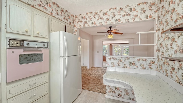 2702 Bedford Way, Sarasota, FL 34239 - kitchen featuring white appliances, wallpapered walls, ceiling fan, and light countertops