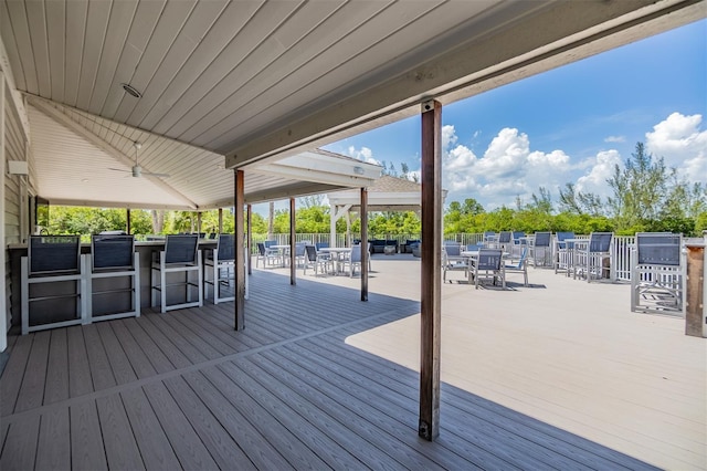 wooden terrace with a ceiling fan and outdoor dining area