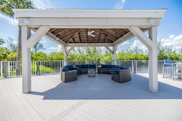 wooden deck featuring a gazebo, outdoor lounge area, and a ceiling fan