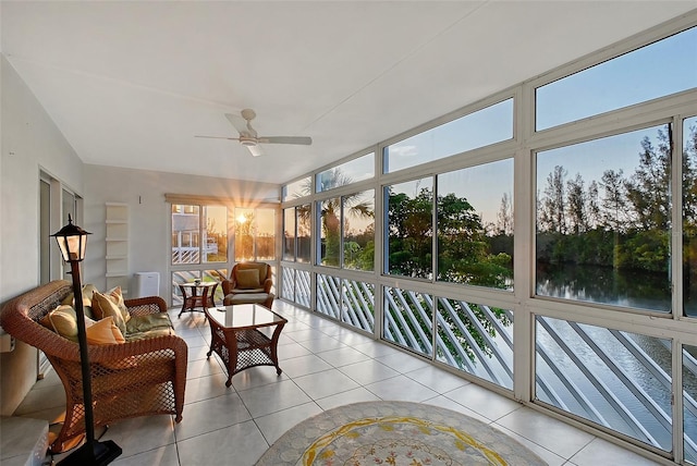 sunroom with tile patterned floors and a water view