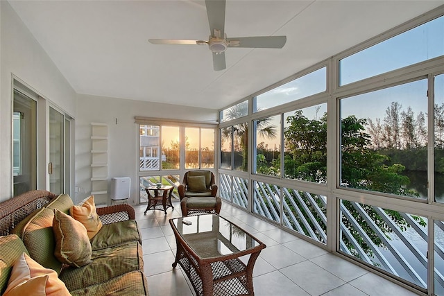sunroom with ceiling fan, plenty of natural light, and tile patterned flooring