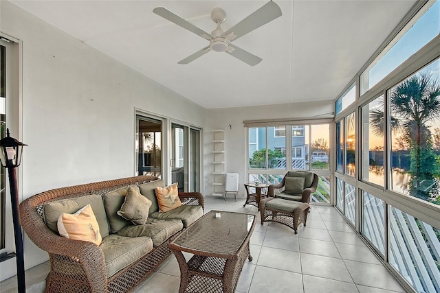 sunroom / solarium with ceiling fan, outdoor lounge area, tile patterned floors, and lofted ceiling