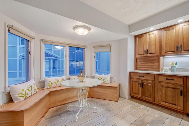 dining area with breakfast area, baseboards, and wood finish floors