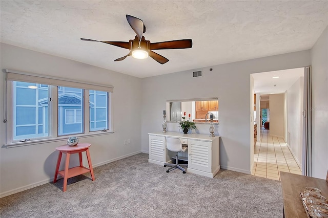 office area featuring light carpet, ceiling fan, and baseboards