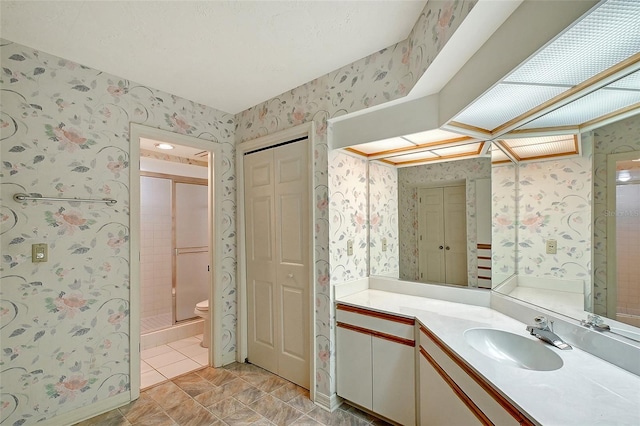 full bathroom featuring wallpapered walls, a closet, vanity, tile patterned floors, and toilet