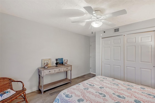bedroom featuring light wood finished floors, a closet, baseboards, and ceiling fan