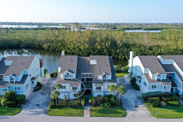 view from above of property with a large body of water and a heavily wooded area