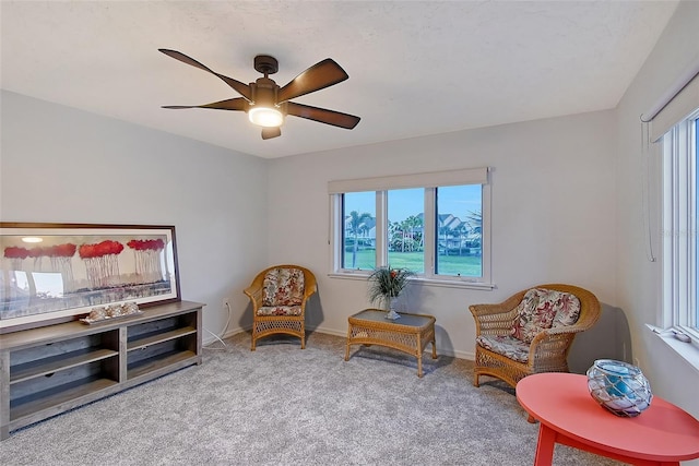sitting room with ceiling fan, carpet floors, and baseboards