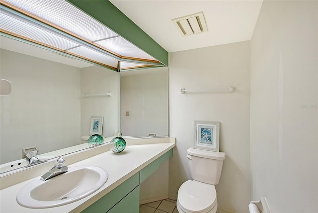 bathroom with toilet, tile patterned floors, vanity, and baseboards