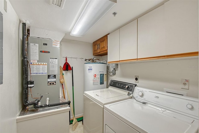 laundry room with cabinet space, washing machine and dryer, water heater, and heating unit
