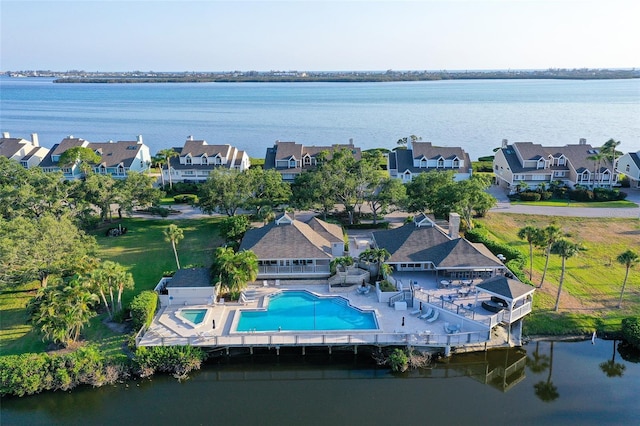 aerial view of residential area with a pool area and a large body of water