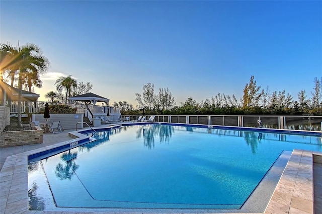 community pool featuring fence, a patio, and a gazebo